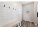 Mud room with shiplap accent wall, coat hooks, bench, and natural light at 23883 E Minnow Cir, Aurora, CO 80016