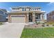 Charming two-story home featuring stone accents, a two-car garage, and a welcoming front porch at 23883 E Minnow Cir, Aurora, CO 80016