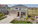 Charming two-story home with a well-manicured lawn, a covered front porch, and a two-car garage at 23883 E Minnow Cir, Aurora, CO 80016