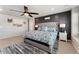 Inviting primary bedroom featuring a padded headboard, black paneled accent wall, and a ceiling fan for added comfort at 23883 E Minnow Cir, Aurora, CO 80016