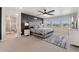 Spacious primary bedroom with paneled accent wall, a ceiling fan, a luxurious upholstered bed, and an ensuite bathroom at 23883 E Minnow Cir, Aurora, CO 80016