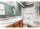 Full bathroom features a wood vanity, decorative mirror, and shower-tub combination at 13500 E Cornell Ave # 302, Aurora, CO 80014