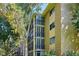 Multi-story apartment exterior showing multiple stories with balconies, surrounded by lush trees at 13500 E Cornell Ave # 302, Aurora, CO 80014