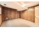 Unfinished basement space featuring wood-paneled walls, offering a versatile area for customization at 13934 W Warren Dr, Lakewood, CO 80228