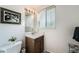 Bathroom with a sink, vanity, framed art, decorative plant, and window at 13934 W Warren Dr, Lakewood, CO 80228