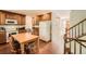 Functional kitchen featuring wood cabinets, modern appliances, and an eat-in area with a view of the staircase at 13934 W Warren Dr, Lakewood, CO 80228
