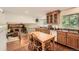 Bright kitchen with wooden cabinets, countertops, table, hardwood flooring, and adjacent view into living room at 13934 W Warren Dr, Lakewood, CO 80228