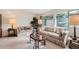 Cozy living room featuring large windows, comfortable seating, and ample natural light at 13934 W Warren Dr, Lakewood, CO 80228