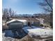 House with a snow-covered yard, driveway, and mountain backdrop at 12838 W Iliff Ave, Lakewood, CO 80228