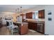 Bright kitchen featuring an island, wood cabinets, and stainless steel dishwasher at 12838 W Iliff Ave, Lakewood, CO 80228