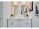 Bright, dual sink bathroom with modern mirrors, lighting and white shaker cabinetry at 1251 S Yosemite Way # 92, Denver, CO 80247