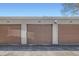Three garage stalls with brown doors and white numbers provide parking at 1251 S Yosemite Way # 92, Denver, CO 80247