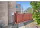 Charming red gate at the side of a brick home offers a private outdoor space at 1251 S Yosemite Way # 92, Denver, CO 80247