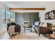 Cozy living room featuring a brick fireplace, wood beams, and modern furnishings at 1251 S Yosemite Way # 92, Denver, CO 80247