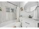 Well-lit bathroom features a tub with shower, marble tile, and sleek fixtures at 709 S Wolcott Ct, Denver, CO 80219