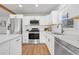 Well-lit kitchen area with quartz countertops, stainless steel appliances and white cabinetry at 709 S Wolcott Ct, Denver, CO 80219