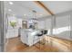 Modern kitchen with white cabinets, quartz countertop island, and hardwood floors at 709 S Wolcott Ct, Denver, CO 80219