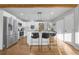 Open-concept kitchen with white cabinets, stainless steel appliances, and island seating at 709 S Wolcott Ct, Denver, CO 80219