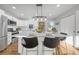 Eat in kitchen island boasts barstool seating, stainless appliances, and modern fixtures at 709 S Wolcott Ct, Denver, CO 80219