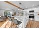 Open concept kitchen featuring quartz countertops, stainless appliances and eat in kitchen island at 709 S Wolcott Ct, Denver, CO 80219