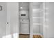 Bright laundry room with front load washer and dryer and open shelving for storage at 709 S Wolcott Ct, Denver, CO 80219