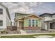 Charming two-story home with green siding, brick accents and white trim around large front windows at 959 Promenade Dr, Superior, CO 80027