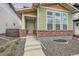 Charming two-story home with green siding, brick accents and white trim around large front windows at 959 Promenade Dr, Superior, CO 80027