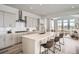 Bright kitchen with island seating, stainless hood vent and appliances overlooking the living room at 959 Promenade Dr, Superior, CO 80027