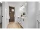Well-lit bathroom with double vanity, decorative mirrors and a walk-in shower with light brown tile at 4574 Walden St, Denver, CO 80249