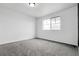 A spacious, empty bedroom with neutral carpet and plenty of natural light from a single window at 4574 Walden St, Denver, CO 80249