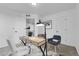 A spacious office with two chairs, a desk with decor and a lamp, and views to two doorways at 4574 Walden St, Denver, CO 80249
