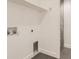 Bright laundry room with white walls, shelving, and gray tile flooring at 3916 N Mariposa St, Denver, CO 80211