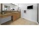 Bathroom with a vanity with granite countertops and drawers, as well as a large mirror and flat screen television at 7330 Centennial Dr, Parker, CO 80138