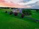 Modern home with a circular driveway surrounded by lush landscaping at sunset at 7330 Centennial Dr, Parker, CO 80138