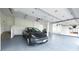 Clean, well-organized garage with a grey epoxy floor, car, and some storage at 7330 Centennial Dr, Parker, CO 80138