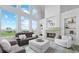 Bright living area with tall windows, a stone fireplace, and modern neutral-toned furniture at 7330 Centennial Dr, Parker, CO 80138