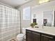 Well-lit bathroom features a vanity with dark cabinets, mirror, toilet, and shower with curtain at 3368 Cranston Cir, Highlands Ranch, CO 80126