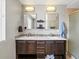 Bathroom featuring double sinks, decorative mirrors, and a tiled backsplash at 3368 Cranston Cir, Highlands Ranch, CO 80126