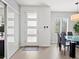 Modern entryway featuring neutral colors, tiled floor, front door with window inserts, and coat hooks at 3368 Cranston Cir, Highlands Ranch, CO 80126