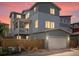 Charming home exterior features a private balcony, two-car garage, and warm exterior lighting at dusk at 3368 Cranston Cir, Highlands Ranch, CO 80126