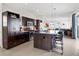 Open-concept kitchen featuring stainless steel appliances, dark cabinets, and a granite island with seating at 3368 Cranston Cir, Highlands Ranch, CO 80126