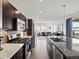 Open kitchen with stainless steel appliances and eat-in island flows seamlessly into the living room at 3368 Cranston Cir, Highlands Ranch, CO 80126