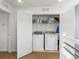 Convenient laundry room featuring a washer and dryer, open shelving, and bi-fold doors at 3368 Cranston Cir, Highlands Ranch, CO 80126