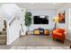 Open-concept living room features a staircase, mounted TV, and stylish décor at 3368 Cranston Cir, Highlands Ranch, CO 80126