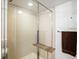 Sleek tiled shower with glass doors, built-in bench, and modern fixtures at 3368 Cranston Cir, Highlands Ranch, CO 80126