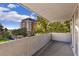 Balcony view of surrounding city buildings and green trees with a concrete wall and sliding glass doors at 740 N Pearl St # 203, Denver, CO 80203