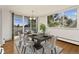 Bright dining room featuring hardwood floors, a modern chandelier, and sliding glass doors to a balcony with city views at 740 N Pearl St # 203, Denver, CO 80203