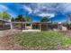 Spacious backyard with a covered patio, green grass, and a tall wooden fence. String lights overhead at 1906 S Vrain St, Denver, CO 80219