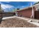 Fenced backyard with a small patio, a red brick wall, a stone path, and string lights at 1906 S Vrain St, Denver, CO 80219