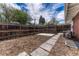 Fenced backyard with a small stone paver patio and a stone path. String lights overhead at 1906 S Vrain St, Denver, CO 80219
